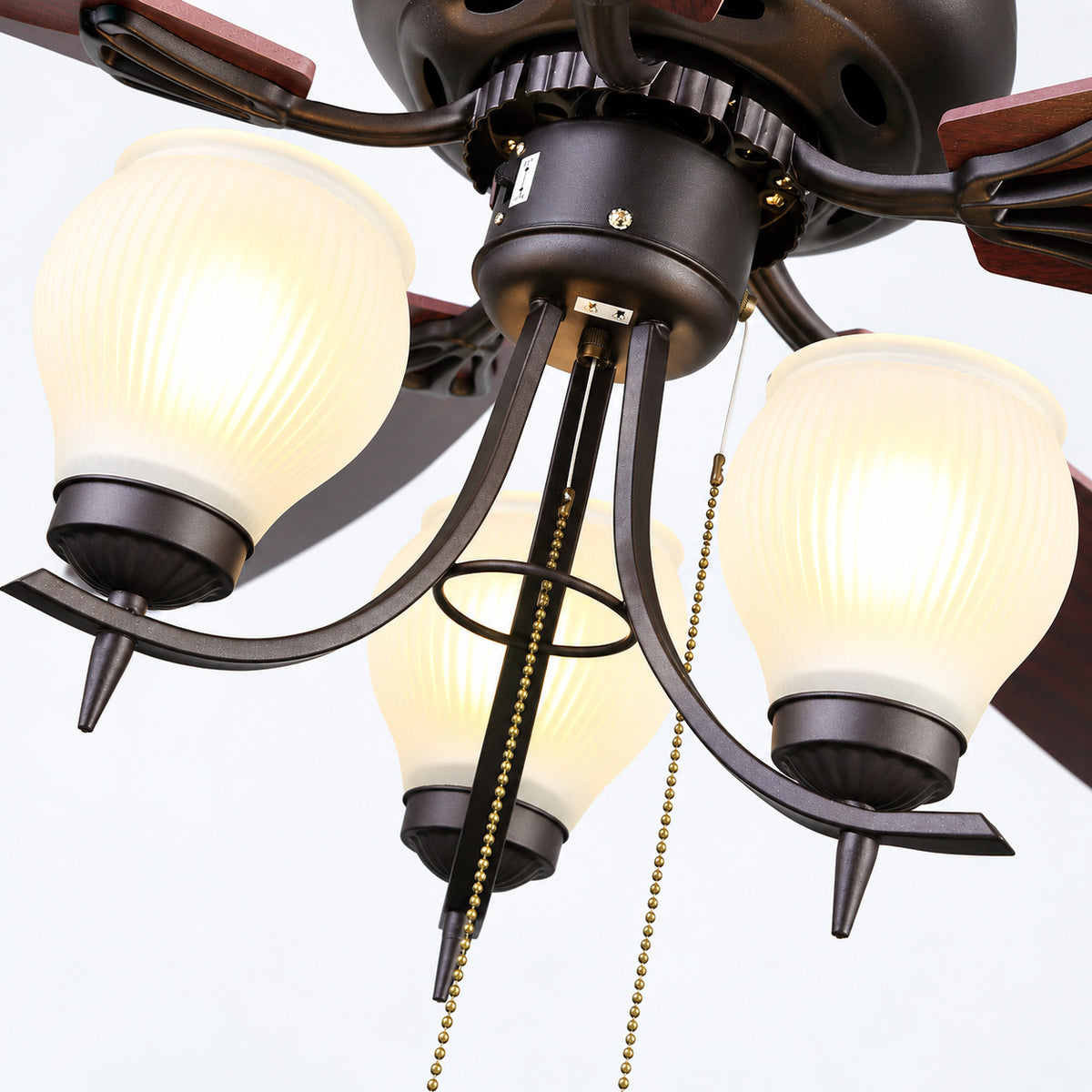 FNC-205 Brown ceiling fan lamp detail showing three fluted cream glass shades, dark metal arms and two beaded pull chains.